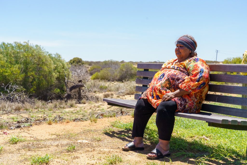 A woman sitting on a park bench, staring into the distance