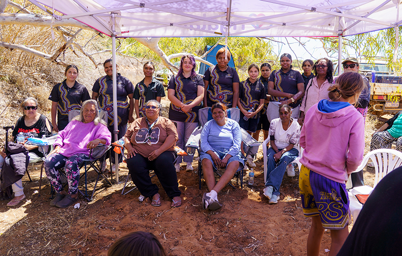 Group of 9 teenage girls taking a photo with Aboriginal Elders on the Gascoyne River